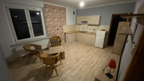 cocina con mesa, sillas y nevera en Kawalerka na wyłączność en Racibórz