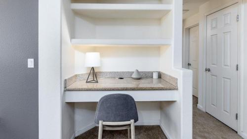 Zimmer mit einem Schreibtisch mit einem Stuhl und einer Lampe in der Unterkunft Landing Modern Apartment with Amazing Amenities (ID5499X01) in San Diego