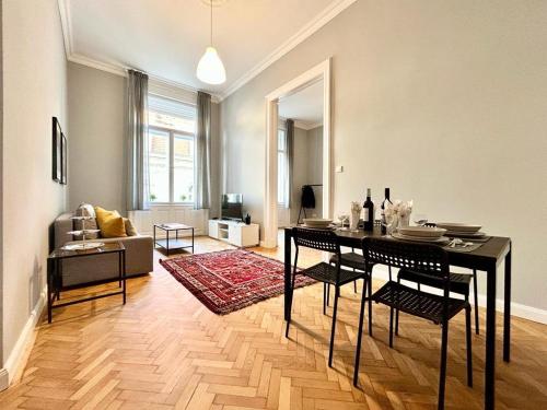 - un salon avec une table et des chaises dans l'établissement Gellert Danube Panorama Apartment, à Budapest