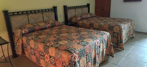 - une chambre avec deux lits et du carrelage dans l'établissement HOTEL PARAISO ESCONDIDO, à Chacala