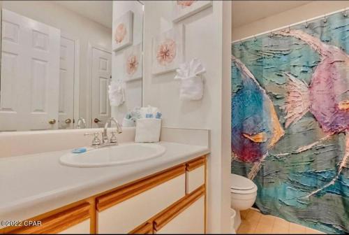 a bathroom with a sink and a painting on the wall at Sunny Daze, Desirable Kid Friendly Resort, 3 minute walk to the Beach, Resort Beachside Pool & Restaurant in Panama City Beach