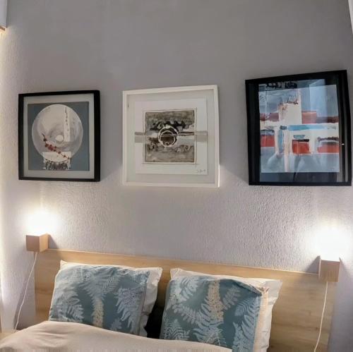 a bedroom with two pictures on the wall and a bed at T3 climatisé avec piscine et vue sur mer in Sète