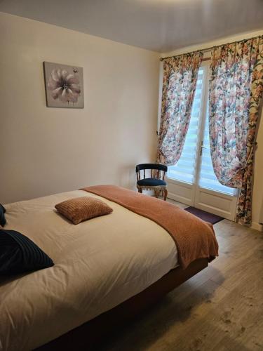 une chambre avec un lit, une fenêtre et une chaise dans l'établissement Maison la vigne haute, à Saint-Viance