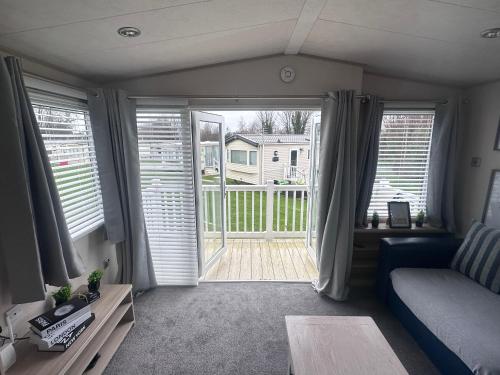 a living room with a couch and a sliding glass door at Seton sands holiday village in Port Seton