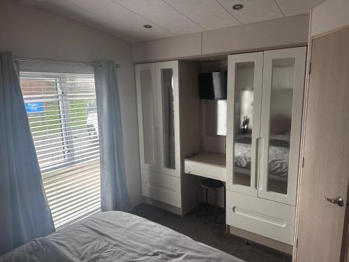 a bedroom with a bed and a dresser and a window at Seton sands holiday village in Port Seton