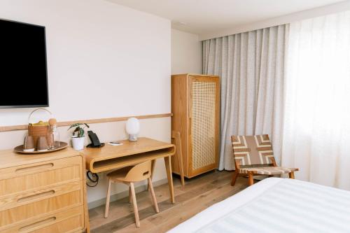 a hotel room with a desk and a bed at The Ryder Hotel in Charleston