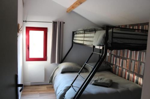 1 dormitorio con 2 literas y ventana en Logement atypique 10 personnes., en Pissos