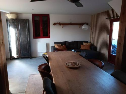 un salon avec une table et des chaises en bois dans l'établissement Gîte L'évasion daugnaguaise, à Pissos