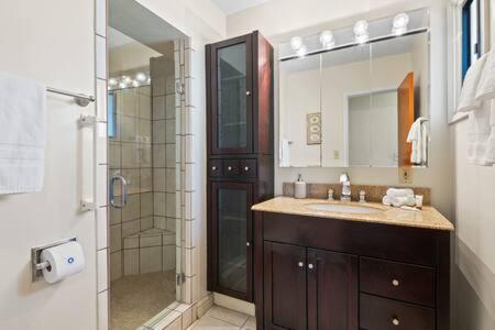 a bathroom with a shower and a sink and a mirror at Spacious 5BR 4B Home in National City w Yard in National City