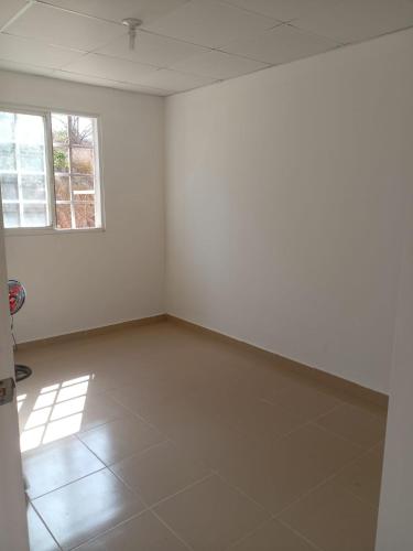 um quarto vazio com paredes brancas e uma janela em Casa Mendoza 