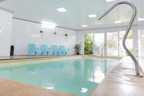 a swimming pool with blue chairs in a building at Hotel Vista La Floresta in La Floresta