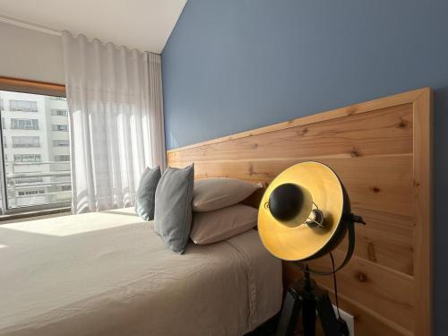 um quarto com uma cama e uma janela grande em Oceanus Executive em Ponta Delgada
