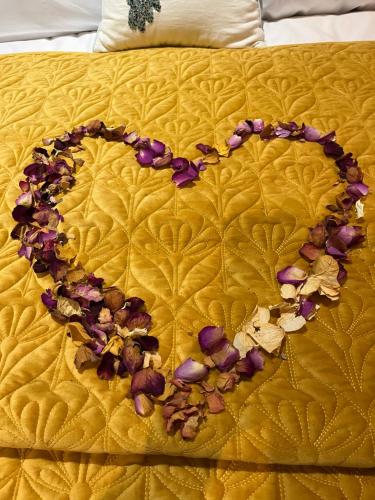 a heart made out of flowers on a bed at Bees cottage Luxury 5* Holiday cottage with Hot Tub in Scarborough