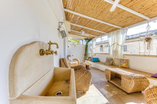 a bathroom with a large tub and wicker furniture at Le Antiche Dimore di Cadia in Ugento