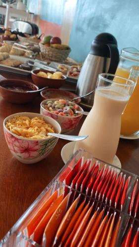a table topped with bowls of food and a bottle of milk at Hotel Vista La Floresta in La Floresta