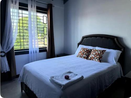 um quarto com uma grande cama branca e uma janela em The Jewel em Kingston