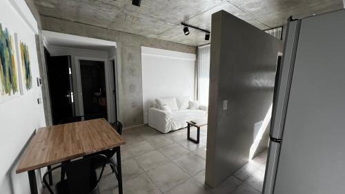 a living room with a table and a white couch at Las Marias Apart I in Necochea