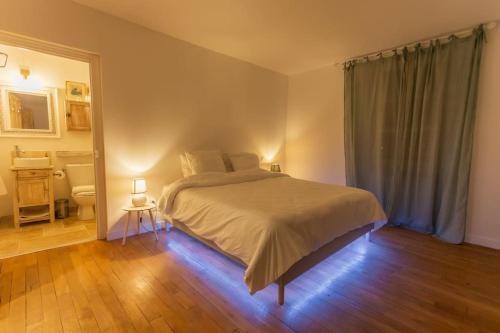 a bedroom with a large bed and a bathroom at L'Estagnole pour 2 personnes, jacuzzi, hammam in Estaing