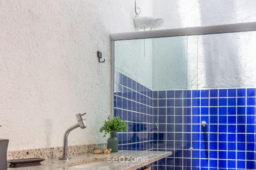 La salle de bains est pourvue d'un lavabo et de carrelage bleu. dans l'établissement VDA - Casas encantadoras e próximas à praia Camaragibe/AL, à Passo de Camarajibe