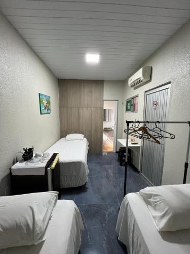 a hotel room with two beds and a bathroom at Pousada da Celma in Fortaleza