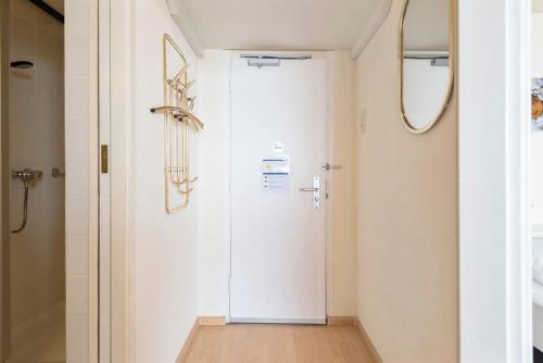 un couloir avec une porte blanche et un miroir dans l'établissement Seaside, à Zandvoort