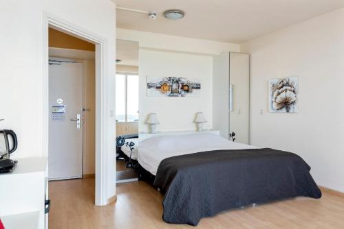 - une chambre blanche avec un grand lit dans l'établissement Seaside, à Zandvoort