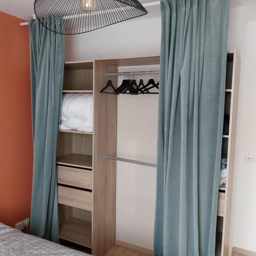 una camera da letto con armadio e tende blu di Appartement cosy proche Disney a Ferrières-en-Brie