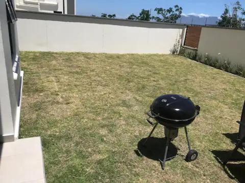 a grill sitting on the grass in a yard at Luxurious Lifestyle in Cape Town
