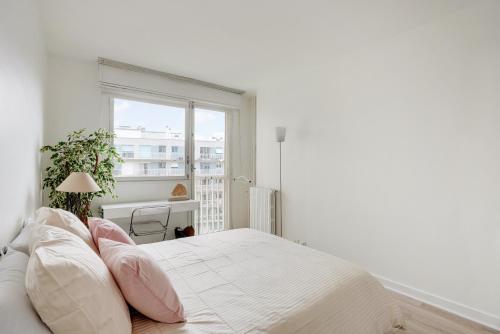 Habitación blanca con cama y ventana en CHAMPS DE MARS - SUFFREN, en París