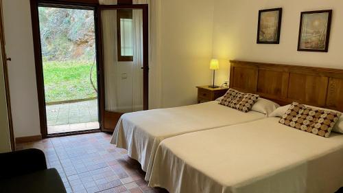 ジェステにあるCasa rural Molino Jaraizの窓付きの客室で、ベッド2台が備わります。