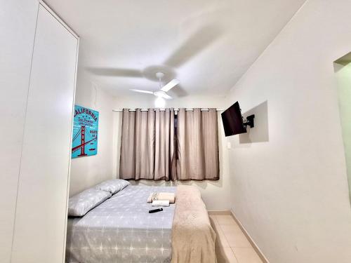 カンポス・ドス・ゴイタカゼスにあるStudio #1 Confortoの白いベッドルーム(ベッド1台、窓付)