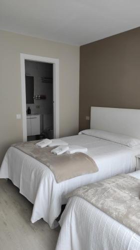 two beds sitting next to each other in a bedroom at Pensión NAVIA A Pontenova in A Pontenova