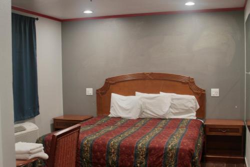 a hotel room with a bed with two pillows at The Broadway Inn in Los Angeles