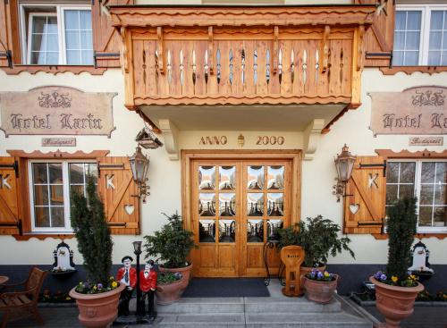 ブダペストにあるホテル カリンの木製のドアとバルコニー付きの建物