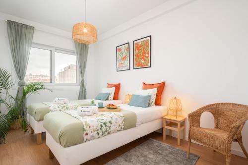 a bedroom with two beds and a chair at Host Wise - Spacious Modern Flat w Balcony in Porto