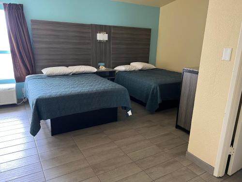 una habitación de hotel con 2 camas en una habitación en EL TEJAS MOTEL, en San Antonio