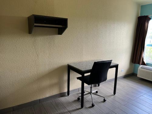 a desk with a chair in a room with a window at EL TEJAS MOTEL in San Antonio