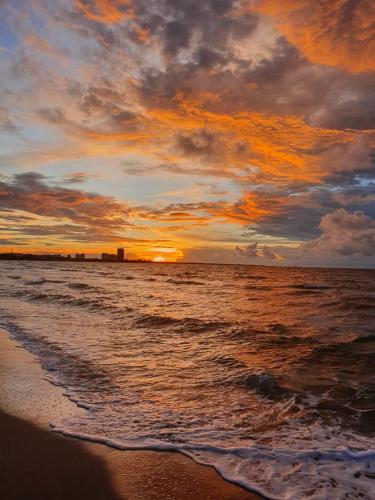 a sunset on the beach with the ocean at Apartamento de descanso Om Shanti Om in Coveñas