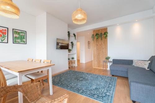 a living room with a table and a blue couch at Host Wise - Spacious Modern Flat w Balcony in Porto