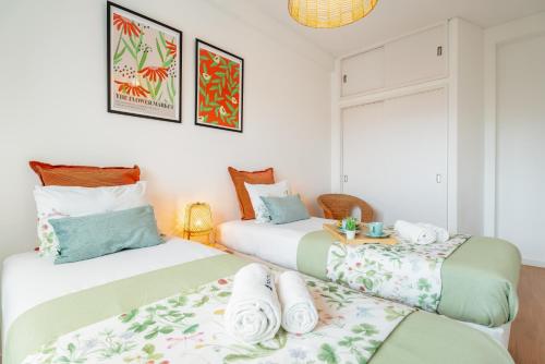 Duas camas num quarto com paredes brancas em Spacious Modern Flat w/ Balcony no Porto
