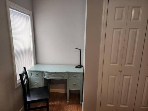 a desk with a lamp and a chair next to a door at Bobby's Beach Bungalow in Milford