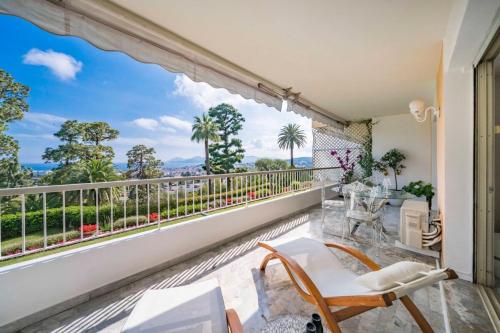 d'un balcon avec vue sur l'océan et les palmiers. dans l'établissement Bright one-bedroom in a quiet area wswimming pool, à Cannes