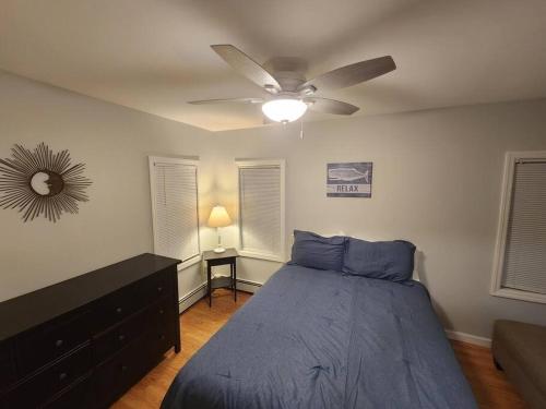 a bedroom with a bed and a ceiling fan at Bobby's Beach Bungalow in Milford