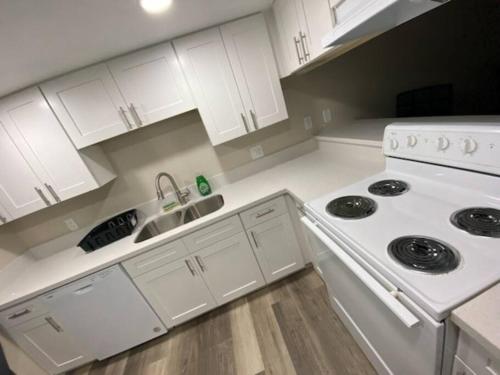 a white kitchen with a stove and a sink at condo in downtown free parking 4 mins frm Freemont in Las Vegas