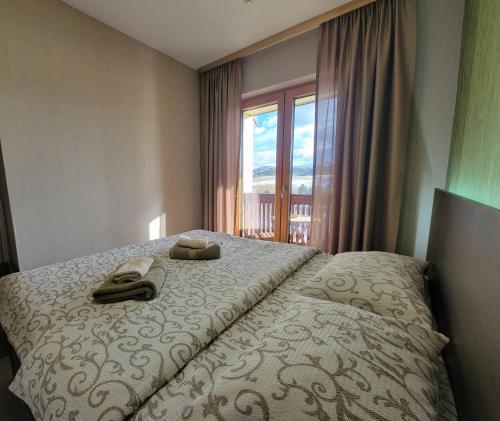 a hotel room with a bed with a window at Apartman 310 in Zlatibor