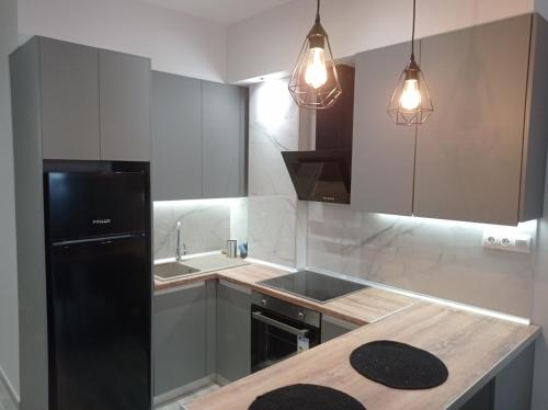 een keuken met een zwarte koelkast en een wastafel bij IN25G in Thessaloniki
