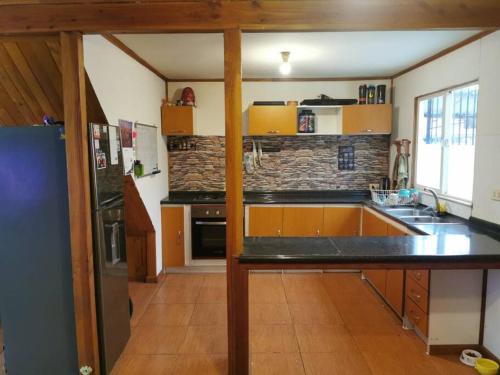 cocina con fregadero y nevera en Alojamiento Casa completa en Puerto Montt, en Puerto Montt