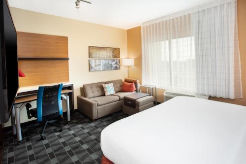 Habitación de hotel con cama y escritorio en TownePlace Suites by Marriott Detroit Belleville en Belleville