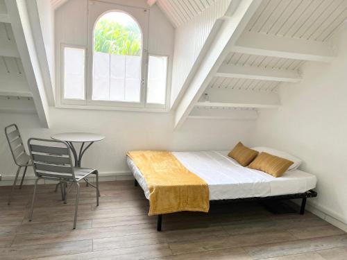 a bedroom with a bed and a table and a window at Studio Cosi Sxm in Marigot