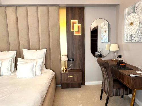 a hotel room with a desk and a bed at Hotel 5 Continents in Craiova